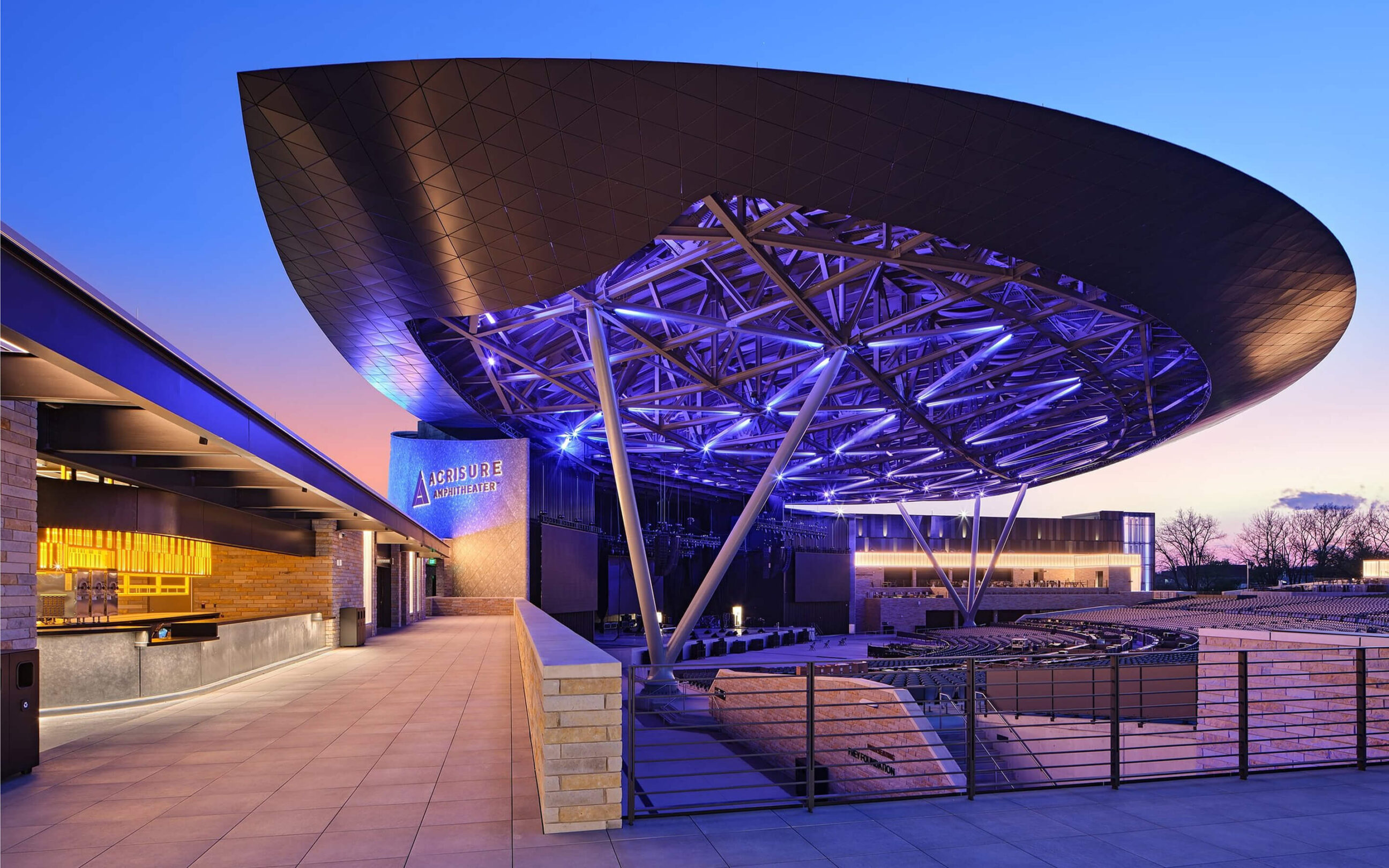 Illuminated Acrisure Amphitheater entrance signage and architectural wayfinding design creating a prominent gateway to the entertainment venue.