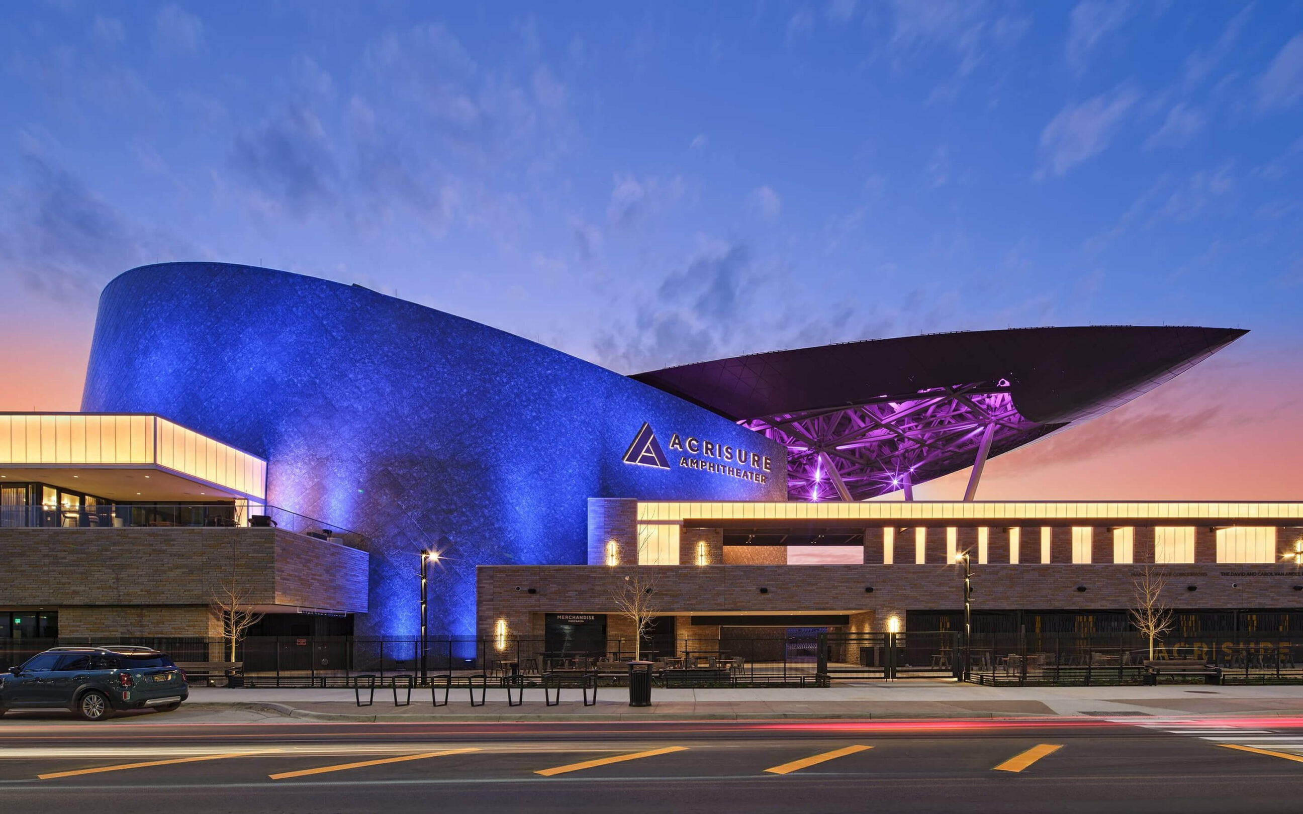 Dusk shot of the Acrisure Amphitheater at night, showcasing the illuminated brand signage.