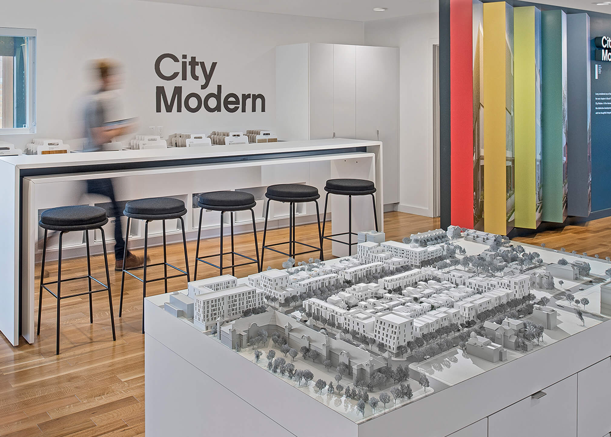 A person walking through an experience center for a mixed-use development, complete with architectural model